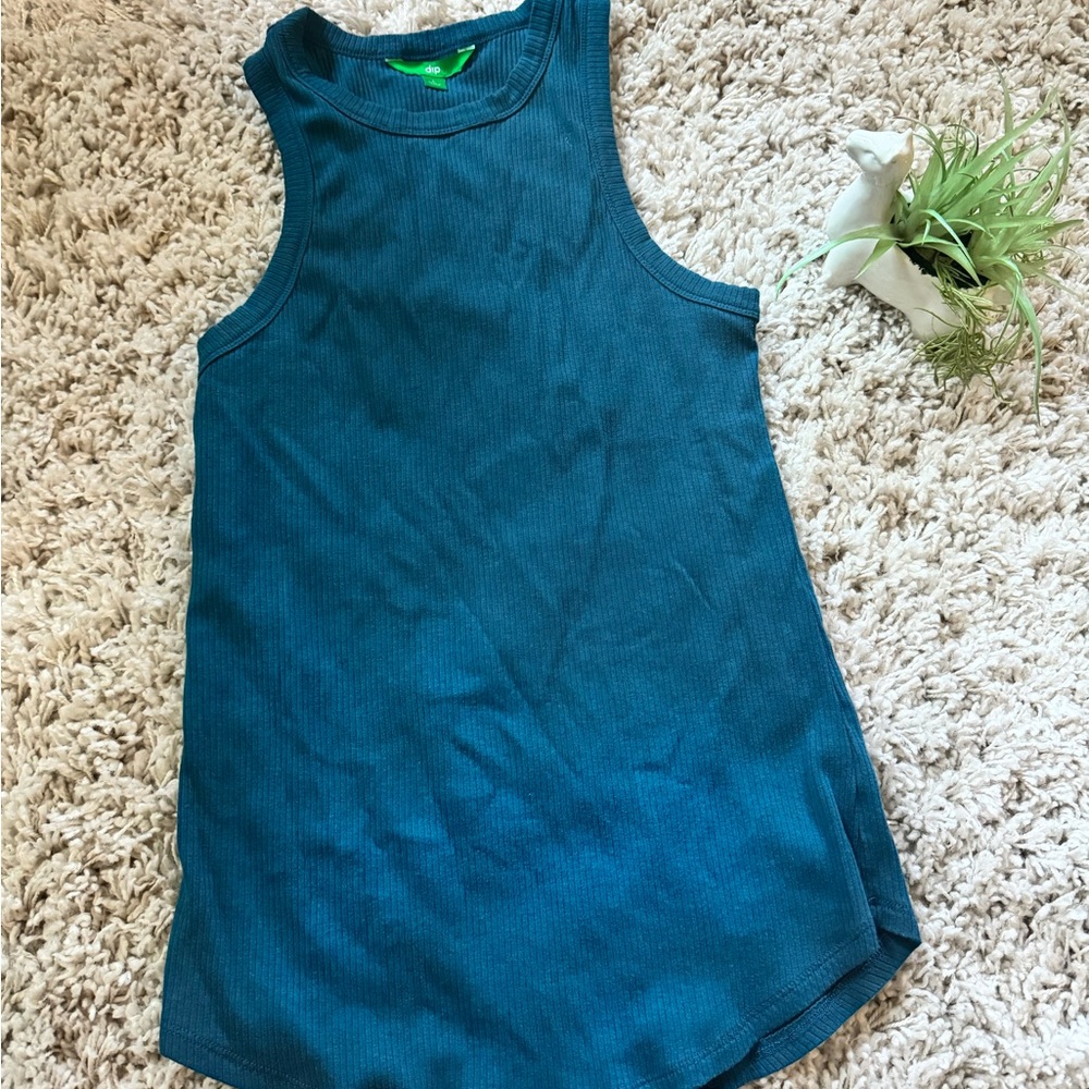 Blue ribbed Dip tank top with a scoop neckline & raw hem, made from 100%…